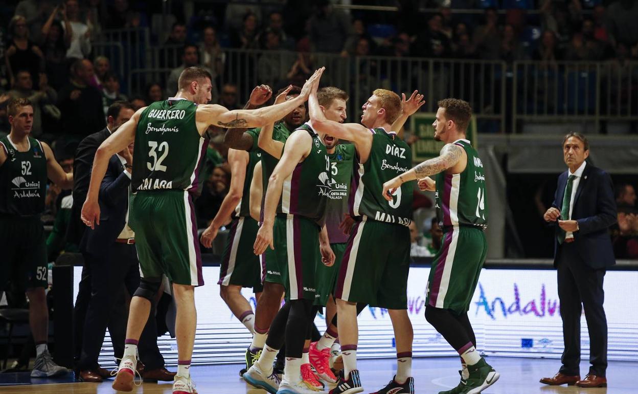 Los jugadores del Unicaja celebran una canasta dantes de un tiempo muerto en un partido. 