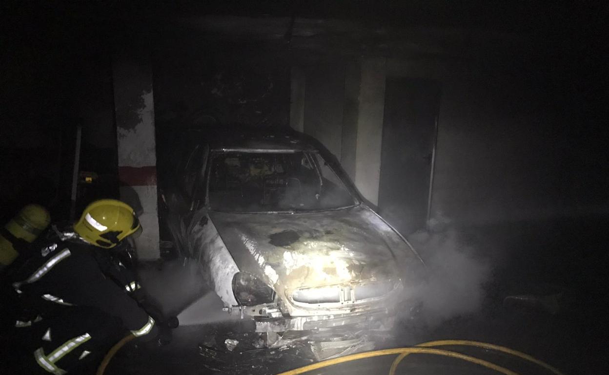 Bomberos apagan un incendio de varios coches en un garaje de la capital