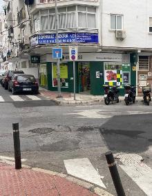 Imagen secundaria 2 - Arriba, parque infantil de Verano Azul, precintado, abajo a la izquierda, dos turistas en el Balcón de Europa, y a la derecha, un supermercado, abierto en el centro de Nerja. 