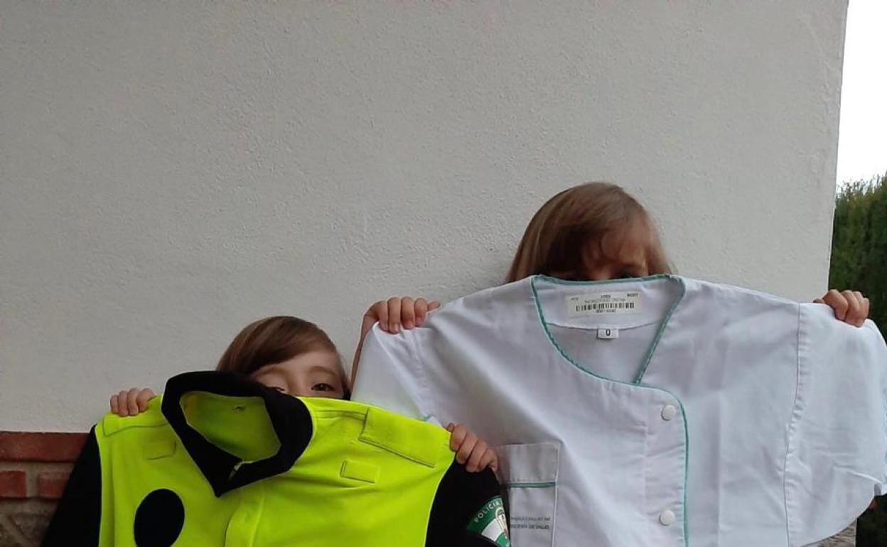 Valentina y Martina muestran los uniformes de sus padres. 