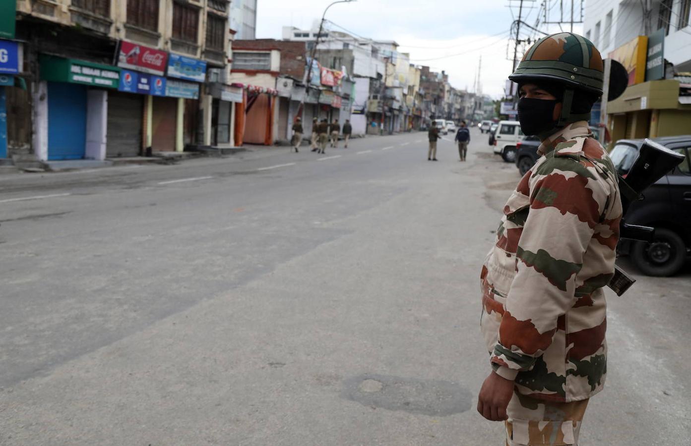 Un soldado paramilitar indio patrulla en una calle desierta durante el cierre en Jammu, India.