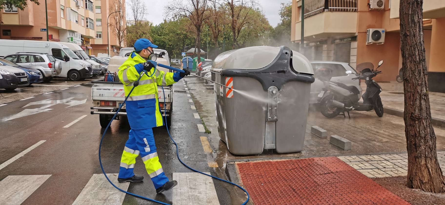 Operario de limpieza, trabajando en unos contenedores.