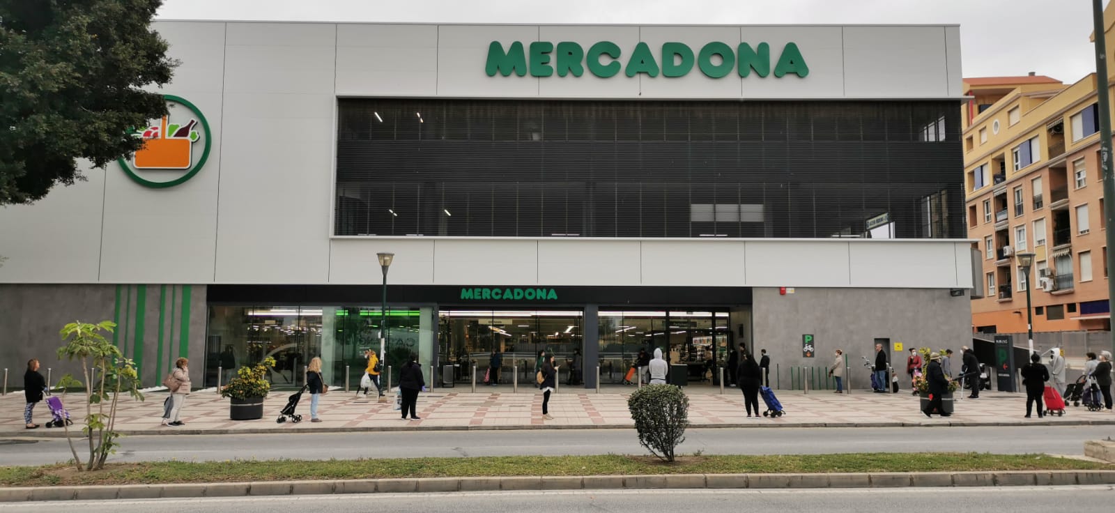 Clientes haciendo cola a las puertas de un supermercado.