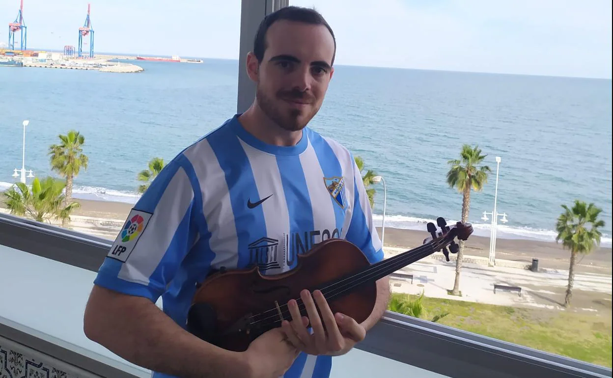 Alejandro Romero posa con su violín desde el balcón de su casa.
