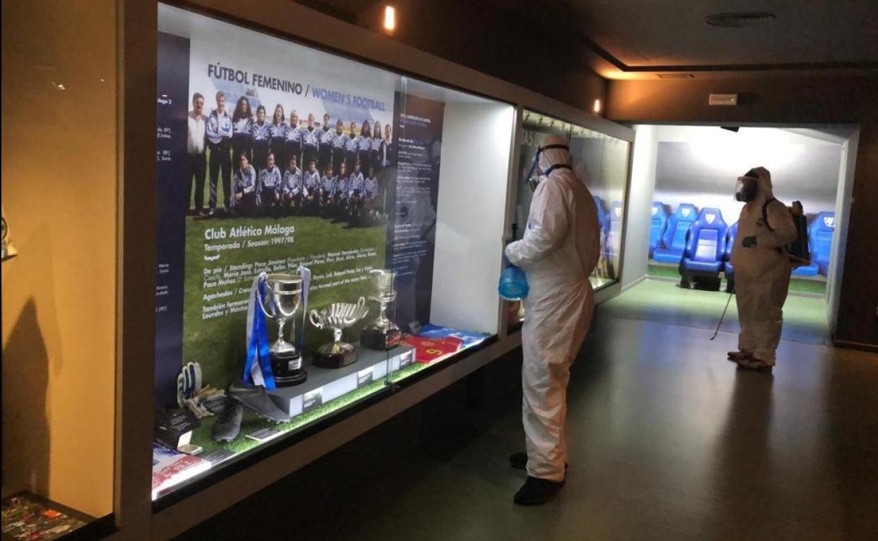 Operarios del Málaga desinfectan parte del Museo del club, ahora cerrado al público, que eestá alojado en una parte del estadio. 