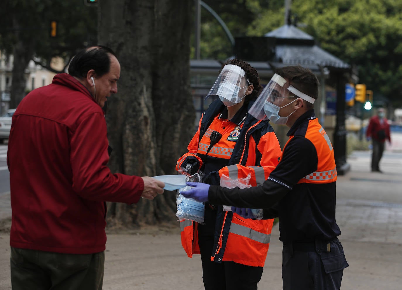 El estado de alarma deja estampas inéditas. Protección Civil comienza en Málaga el reparto de mascarillas a los trabajadores en los transportes públicos.