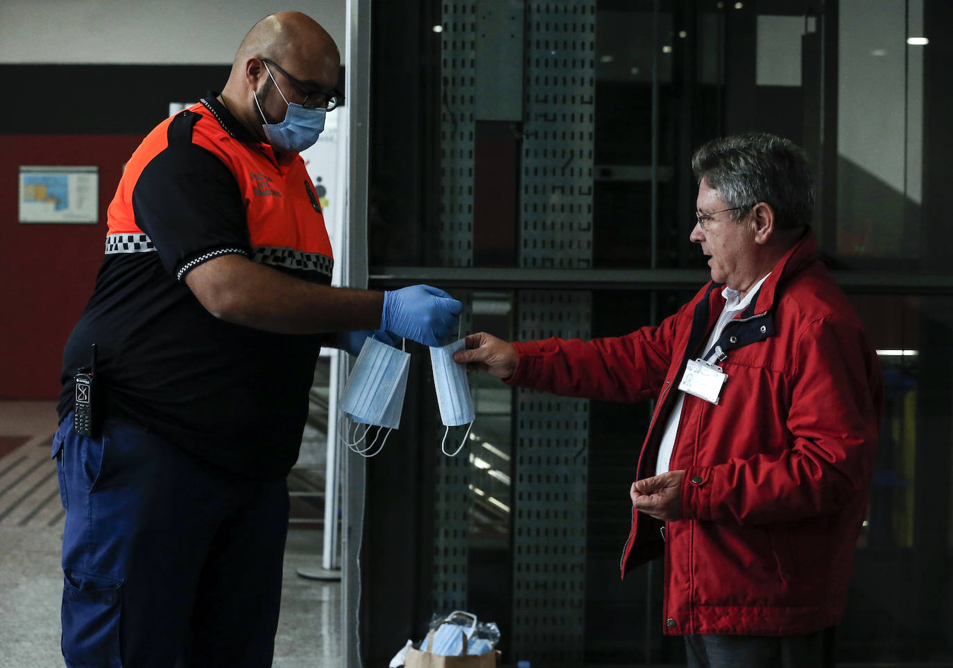 El estado de alarma deja estampas inéditas. Protección Civil comienza en Málaga el reparto de mascarillas a los trabajadores en los transportes públicos.