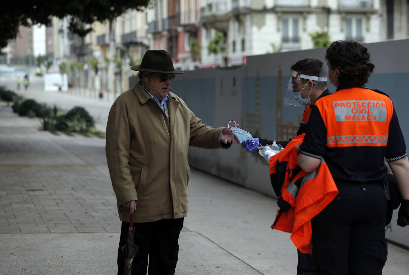 El estado de alarma deja estampas inéditas. Protección Civil comienza en Málaga el reparto de mascarillas a los trabajadores en los transportes públicos.