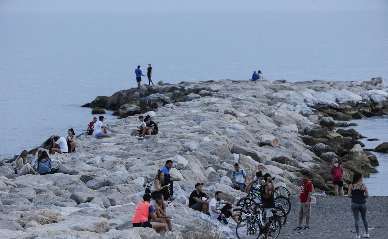 Varios grupos de jóvenes sin mascarillas y sin mantener las distancias en una playa de Málaga. 