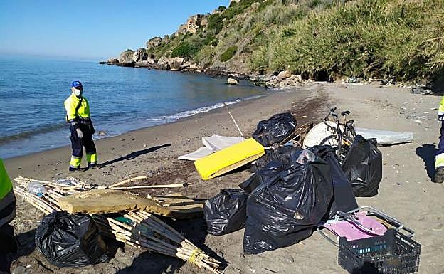 Imagen principal - Arriba, basura y enseres retirados en la playa de La Caleta de Maro; debajo a la izquierda, despliegue de la Guardia Civil en la zona, y a la derecha, embarcación utilizada para trasladar la basura y los enseres intervenidos. 