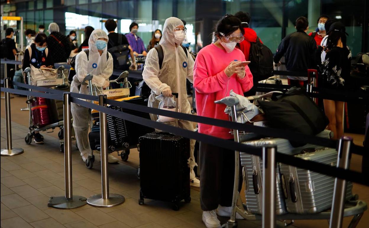 Pasajeros hacen cola en el aeropuerto de Heathrow para embarcar en un vuelo a China.