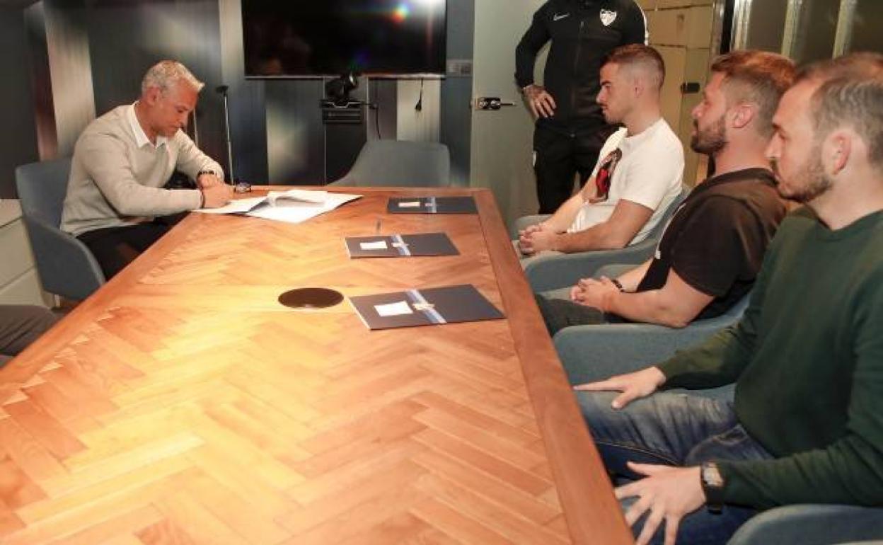 Sergio Pellicer, en el momento de la rúbrica del documento, en una mesa junto a sus ayudantes Manolo Sánchez, Dani Lima y Julio Rodríguez. 