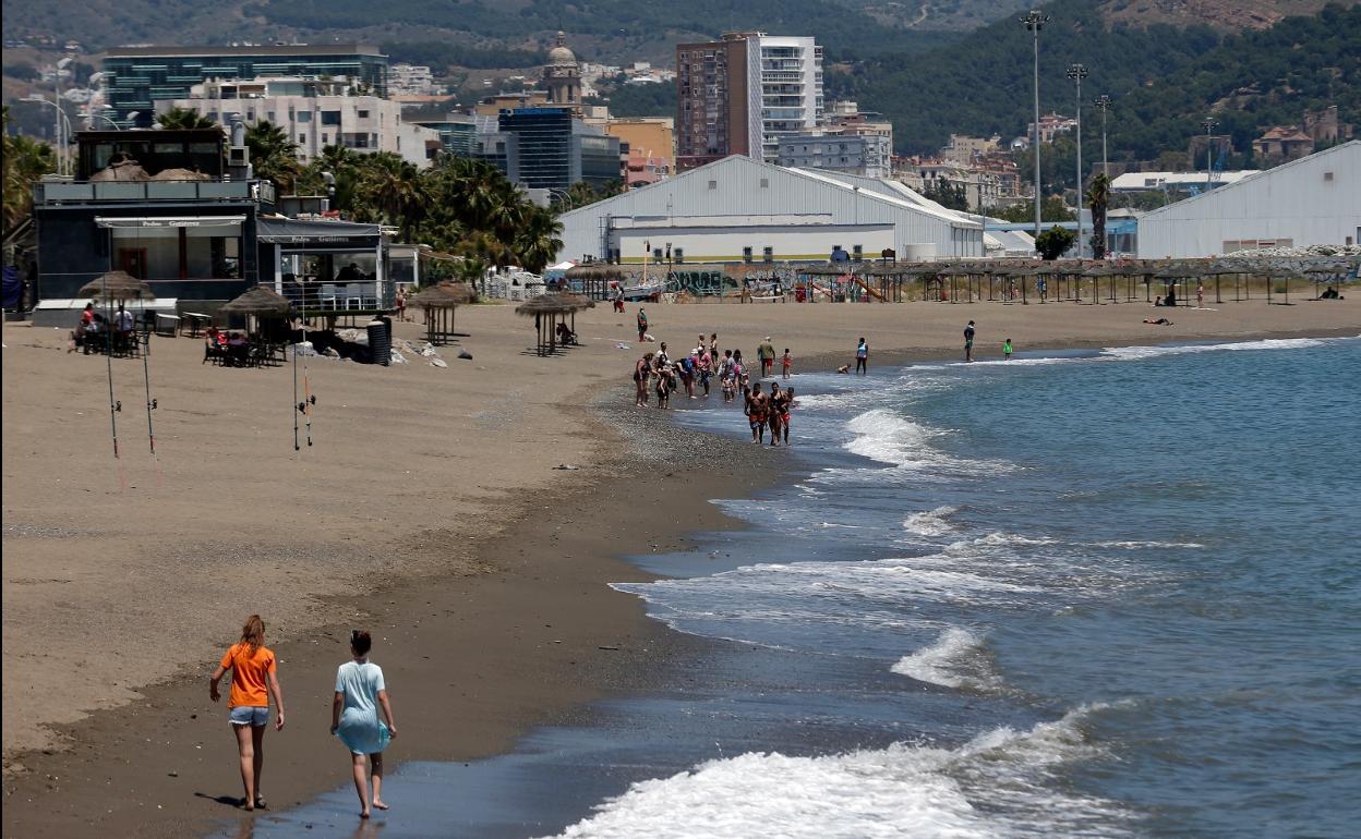 Personas pasean por la orilla de la playa en Huelin. / Ñito Salas