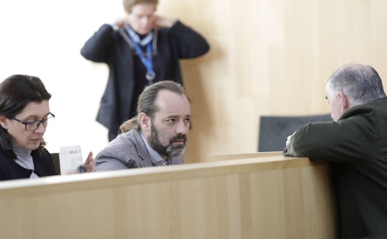 Cassá en su escaño, durante un pleno de la institución, conversando con Manuel Marmolejo. 