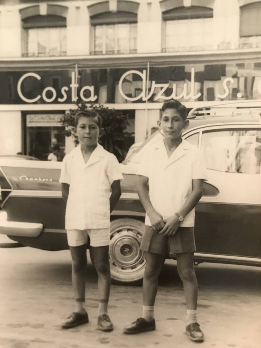 José María Martín Carpena y Ángel Martín Carpena. Los dos hermanos posan para la foto, frente a la tienda de tejidos que había en la Plaza de la Constitución. 