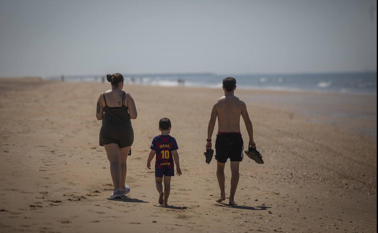 Una familia pasea este jueves por la playa de Punta Umbría en Huelva