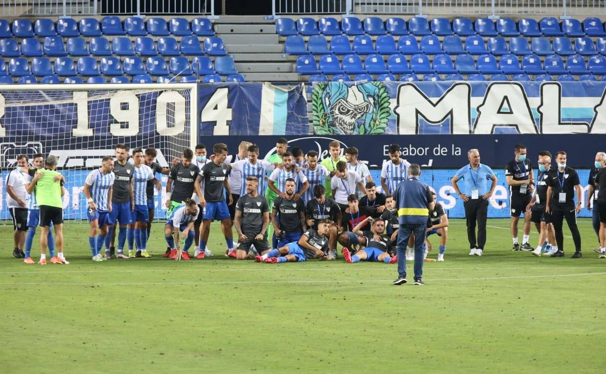 La plantilla del Málaga al completo, entre jugadores y miembros del cuerpo técnico, posaron para una foto histórica en el césped de La Rosaleda.