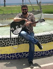 Imagen secundaria 2 - Adolfo Flores, con su guitarra, y portada del nuevo disco de su grupo Motel Caimán.