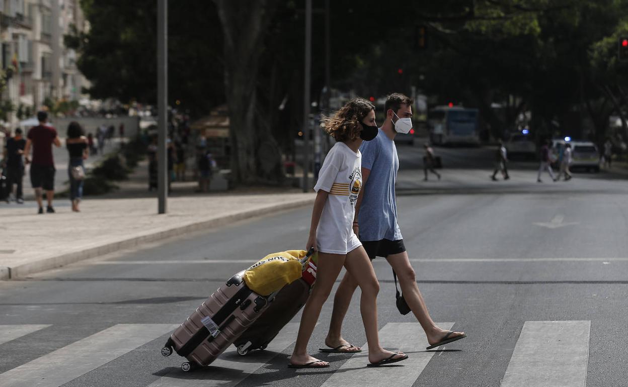 Turistas, con sus maletas, se dirigen a su alojamiento en el Centro de Málaga. 