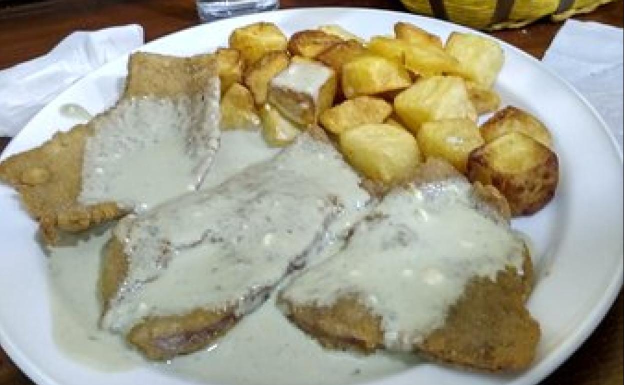 Vista de un escalope con patatas cabrales.
