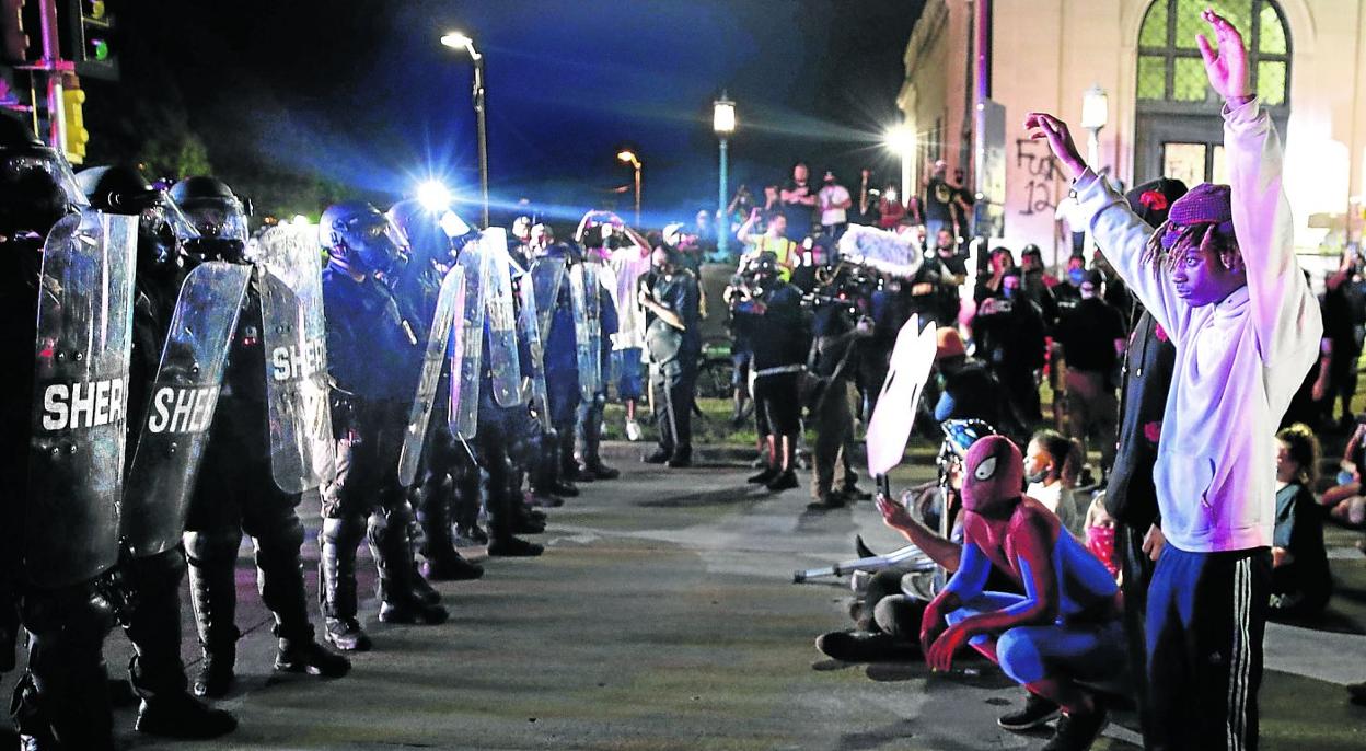 Manifestantes se encaran con agentes antidisturbios durante las manifestaciones celebradas la noche del martes en Kenosha por el tiroteo policial a Jacob Blake. KAMIL KRZACZYNSKI/afp