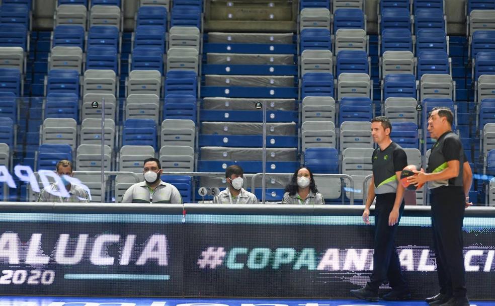 Los componentes de la mesa de anotadores con mascarilla y protegidos por una mampara de metacrilato en presencia de los árbitros .