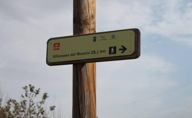 Imagen principal - Arriba, este itinerario homologado tiene una longitud de 28 kilómetros.. Abajo, a la izquierda, el sendero está señalizado con las franjas roja y blanca, y, a la derecha, hito de la ruta.