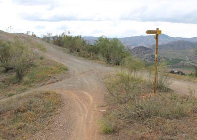 Imagen secundaria 1 - Arriba, en este punto comienza el ascenso. Abajo, aunque la ruta no es compleja, hay que estar muy atentos a las indicaciones, y, a la derecha, encrucijada de caminos.