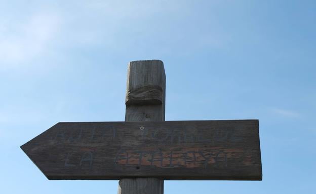 Imagen principal - Arriba, cartel que indica el sentido en el que ir. Abajo, una de las subidas que hay que afrontar, y, a la derecha, vista panorámica de la presa de La Viñuela.