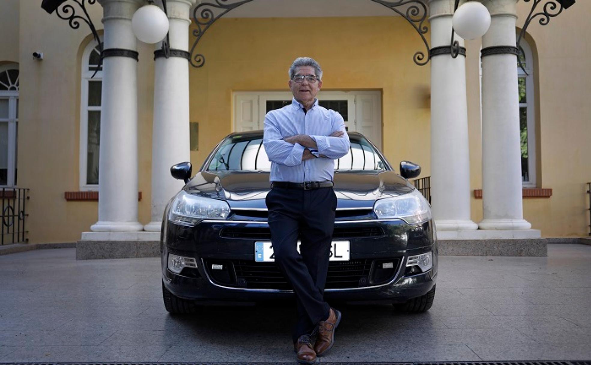 Victoriano Pelayo se apoya en el coche oficial del subdelegado del Gobierno, un Citroën. 