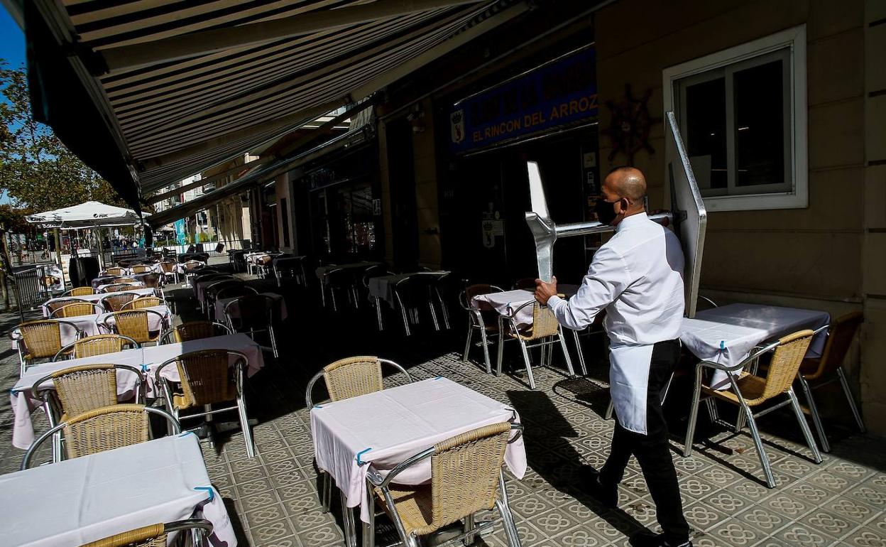 Camarero en la terraza de un restaurante sin clientes debido a la pandemia. 