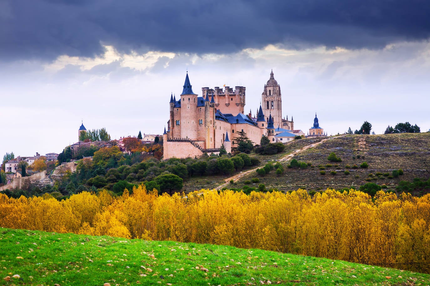 Alcázar de Segovia (España). Este sitio declarado Patrimonio de la Humanidad por la UNESCO es uno de los castillos-palacios más distintivos de toda España y de Europa. En lo alto de la ciudad, sus muros son testigos privilegiados de la historia de España. Austero, como lo eran los reyes castellanos, elevado sobre la roca en la confluencia de los valles del Eresma y el Clamores, parece guardar la ciudad. Su bella Torre del Homenaje, a menudo comparada con la proa de un barco navegando entre los ríos, es de una belleza impresionante. Los turistas comprueban admirados que la fortaleza forma una parte viva de esta ciudad castellana, elegida como lugar de residencia por muchos de los monarcas de la dinastía Trastámara. Vale la pena visitar el Salón de Ajimeces con su colección de obras de arte, el Salón de los Reyes y el Salón del Trono. Pero hay que dedicar tiempo a curiosear el exterior y contemplar su espectacular perfil desde el borde del Eresma, según detallan desde la web Jetcost.es 