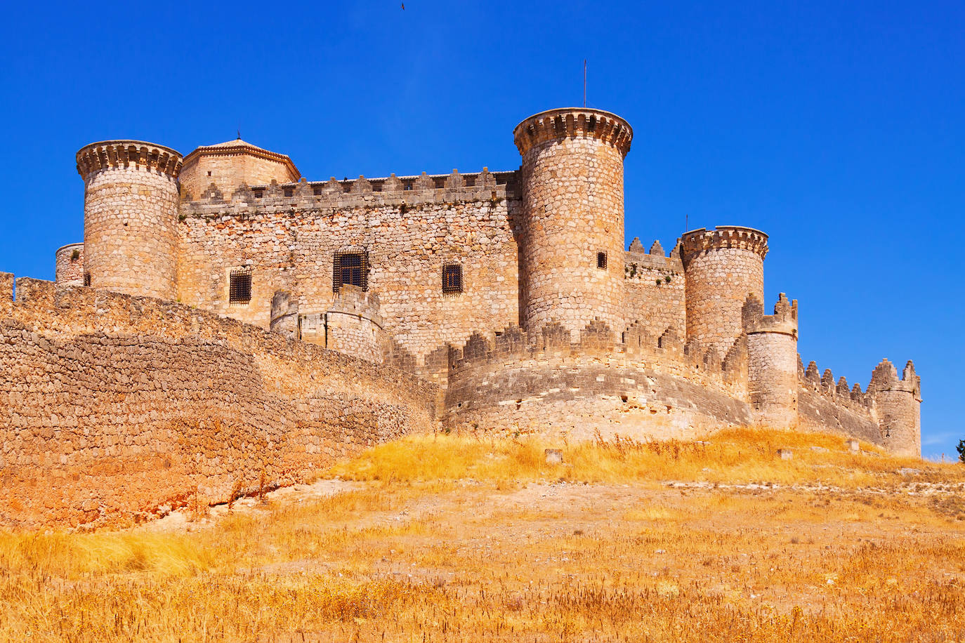 Castillo de Belmonte (España). Fue encargado por D. Juan Pacheco, Marqués de Villena, para utilizarlo como vivienda propia en su ciudad natal. Es un castillo gótico-mudéjar, obra del Maestro Hanequín de Bruselas. Se construyó sobre el monte de San Cristóbal con una planta única. El patio de armas es un triángulo equilátero y a partir de él se desarrolla el resto del edificio. La forma del castillo es una estrella de 6 puntas y al final de cada una de ellas hay una torre cilíndrica, según detallan desde la web Jetcost.es