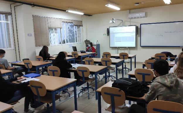 Imagen principal - Arriba, un aula del IES Mediterráneo, con la mitad de alumnos que acuden a clase en días alternos. Debajo, un aula modular en el colegio El Pinar. A la derecha, clase al aire libre en Novaschool. 
