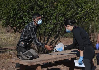 Imagen secundaria 1 - Arriba, Jesús ofrece mascarillas de repuesto a Rafael, que vive en un cajero automático. Abajo, a la izquierda, Gabriel le enseña su DNI a Estefanía. Al lado, la unidad de calle supervisa el lugar donde viven varias personas, debajo del Puente de Arroyo Jaboneros 