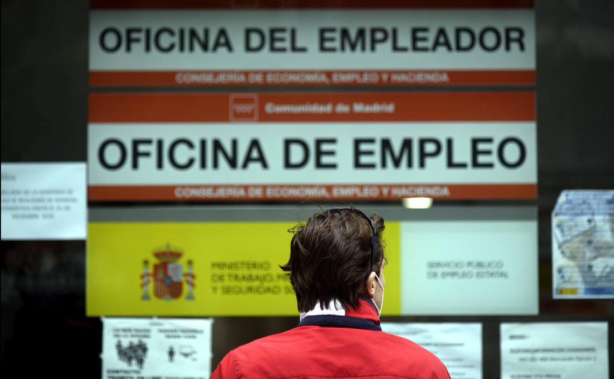 Una persona pasa al lado de una oficina de empleo.