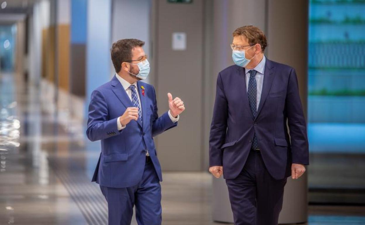 El presidente de la Generalitat valenciana, Ximo Puig, conversa con el vicepresidente de la Generalitat de Cataluña en funciones de presidente, Pere Aragonès.