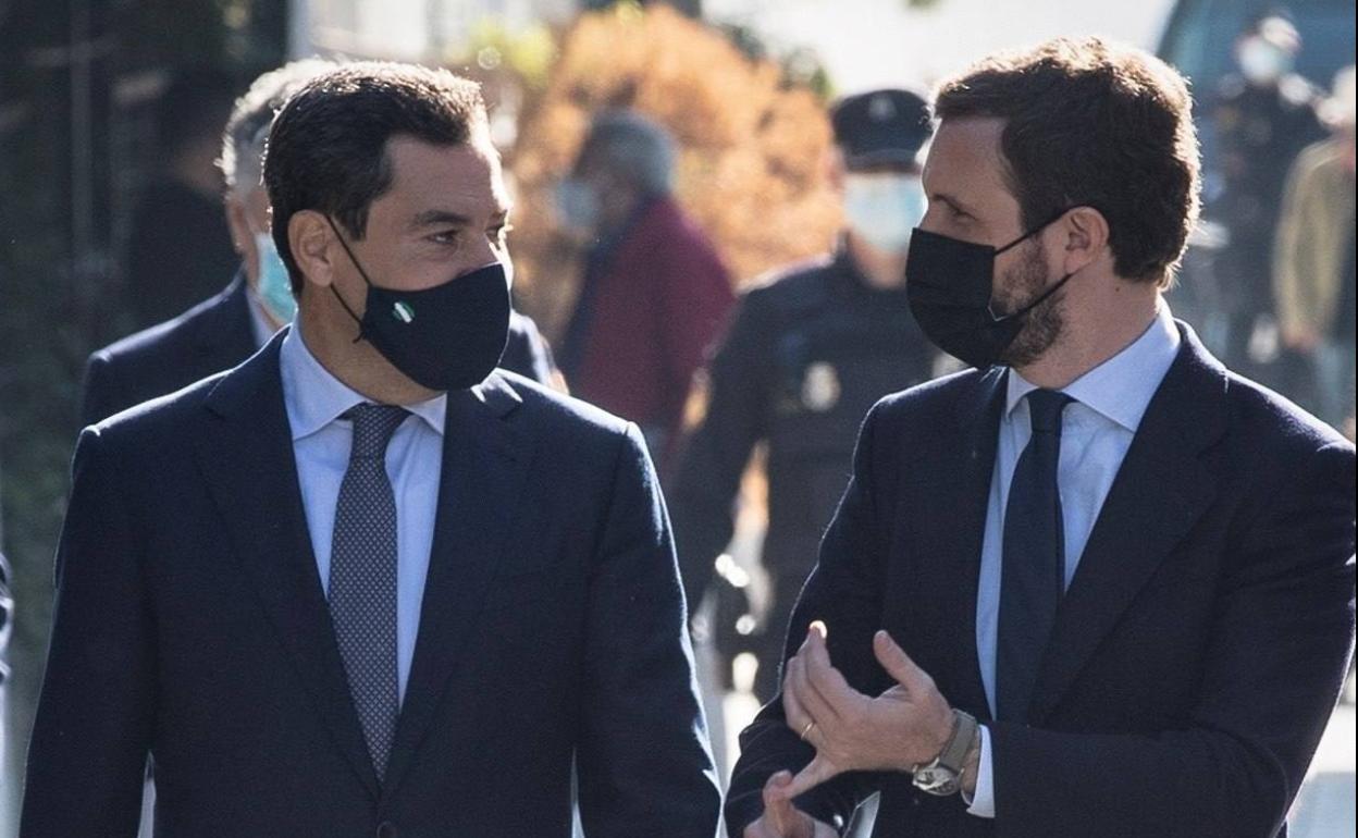 El presidente del Partido Popular, Pablo Casado (d), conversa con el presidente del PP-A y jefe del Ejecutivo regional, Juanma Moreno, a su llegada hoy a Sevilla.