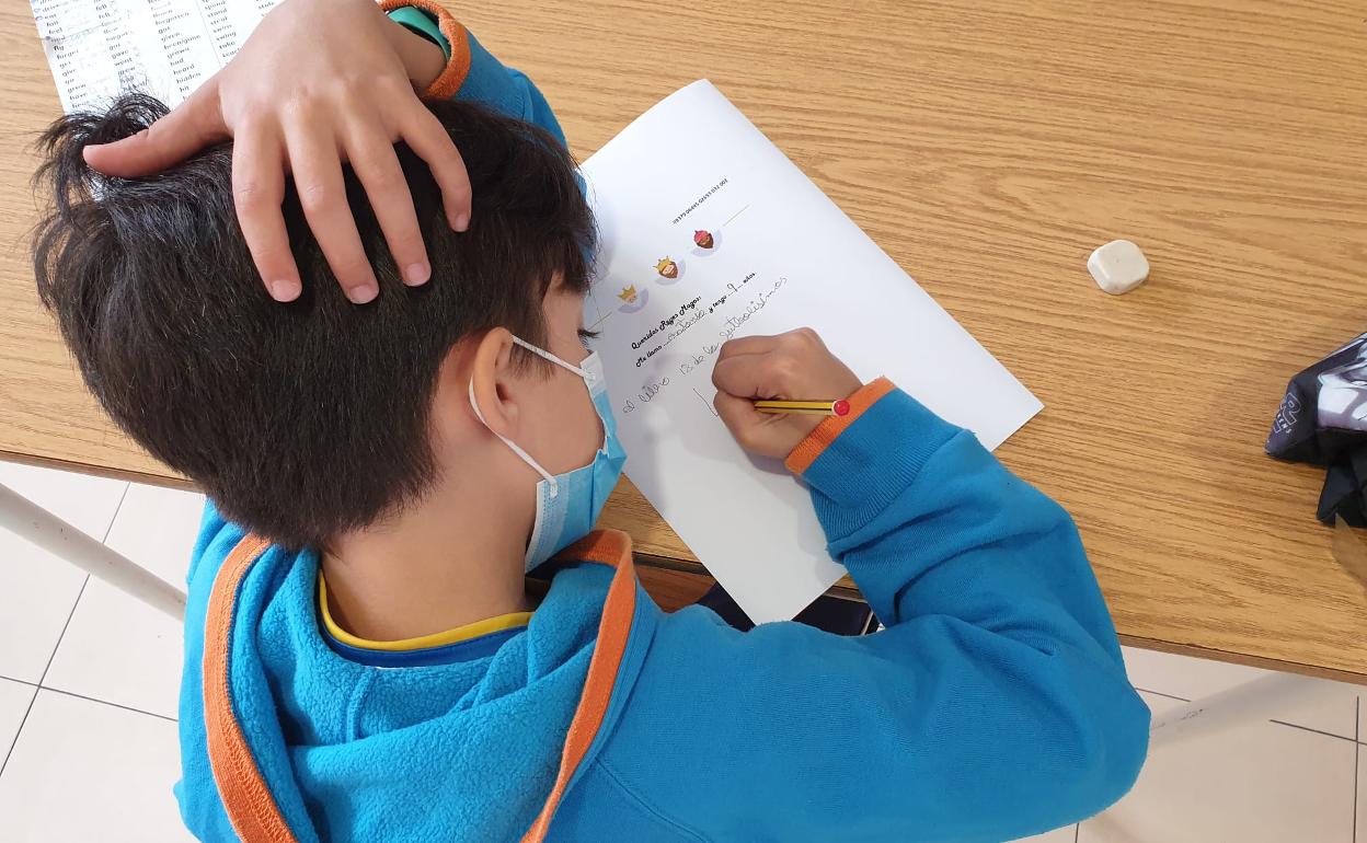 Uno de los pequeños de la Asociación Nena Paine, escribiendo su carta.