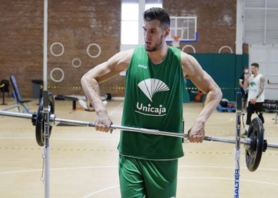 Imagen secundaria 1 - Rubén Guerrero, en un partido del Unicaja, en el gimnasio con unas pesas y demostrando su altura (2,12 metros) junto a una señal de aparcamiento vertical. 