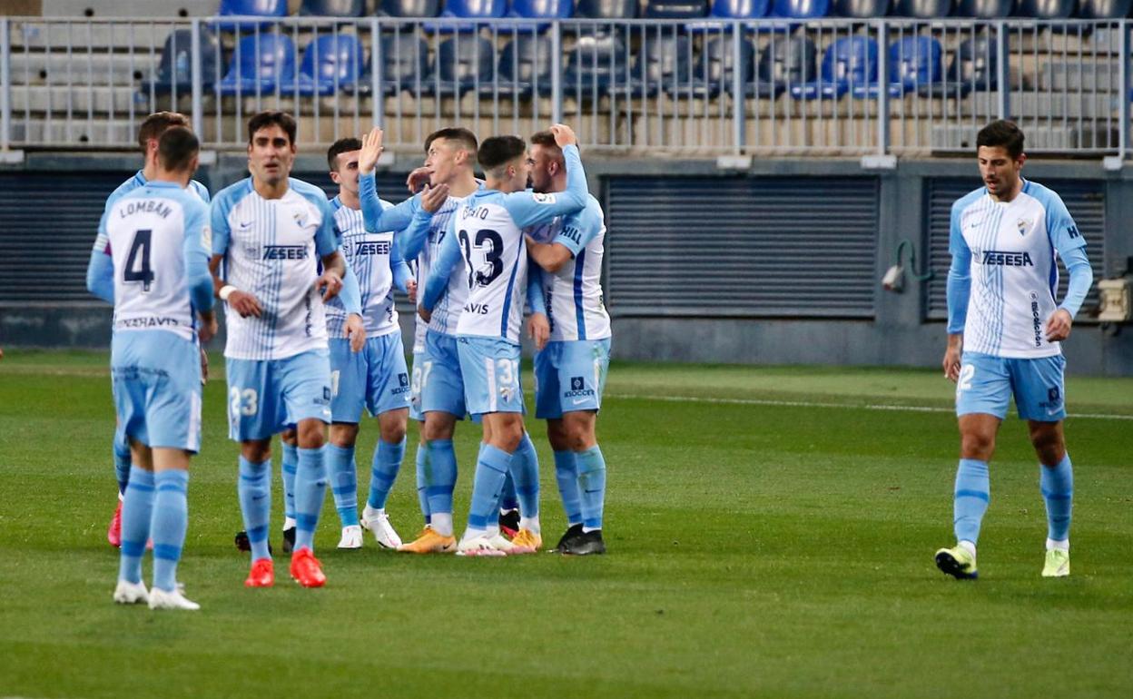 Jugadores del Málaga celebran el gol conseguido en el partido contra el Oviedo, con el autor del tanto, Rahmani, en el centro del abrazo de grupo.