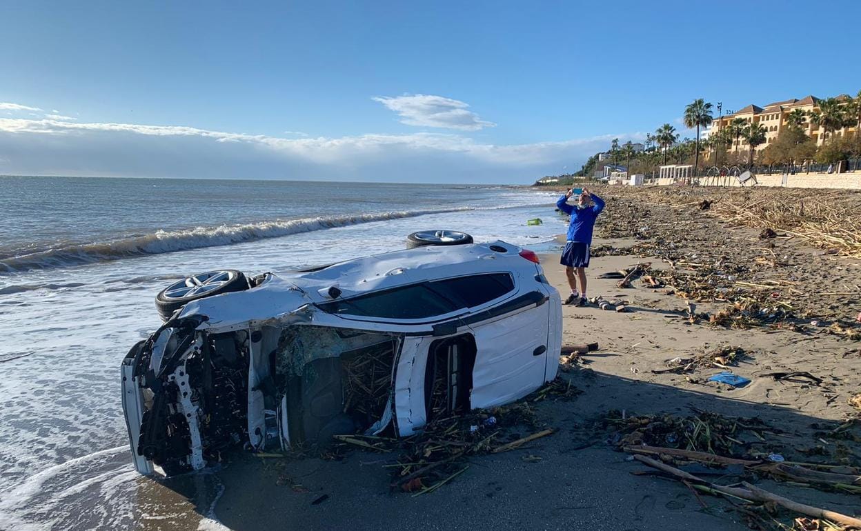 Un coche, ayer por la mañana en la orilla de una playa de Fuengirola. 