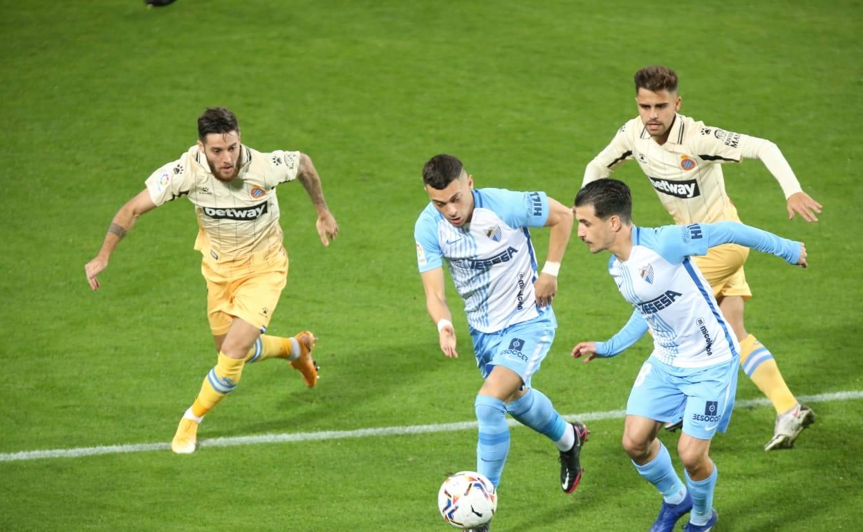 Rahmani conduce el balón con Matos pendiente de doblarle ante la vigilancia de Miguelón y Melendo, del Espanyol (líder). 