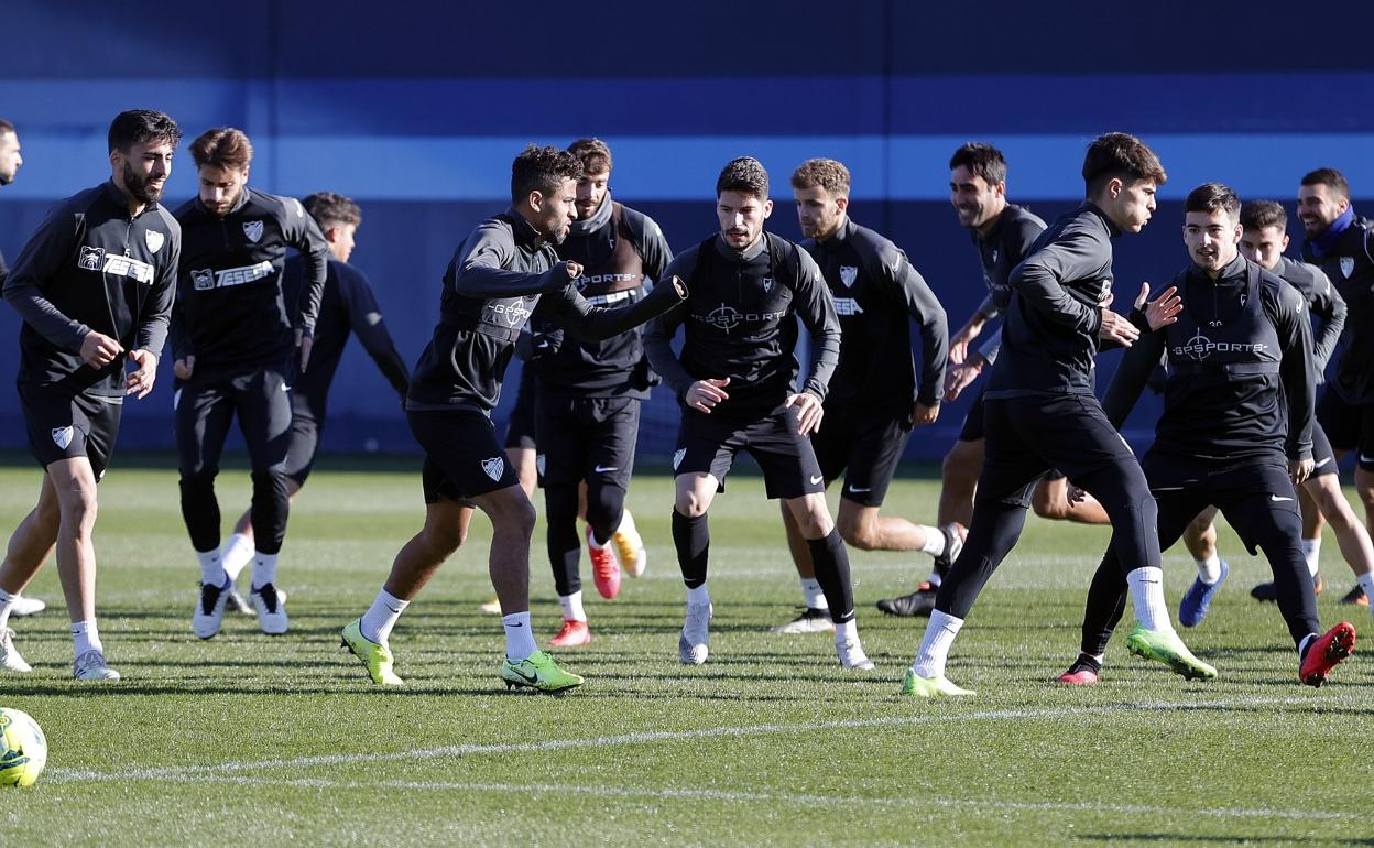 Jugadores del Málaga hacen ejercicios de calentamiento en uno de los últimos entrenamientos del equipo.