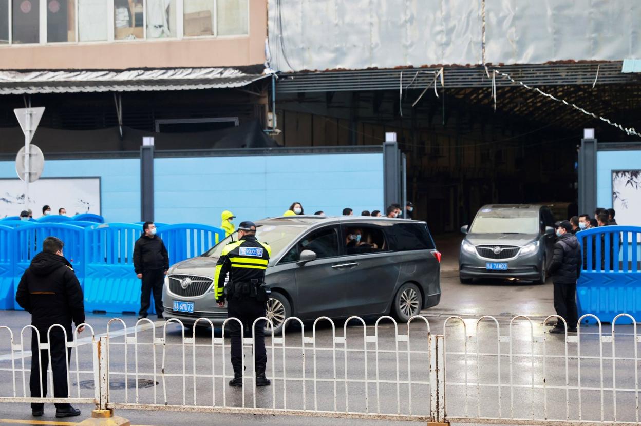 Una caravana de coches traslada a los expertos de la OMS fuera del mercado de Huanan, en la ciudad china de Wuhan. thomas peter/reuters