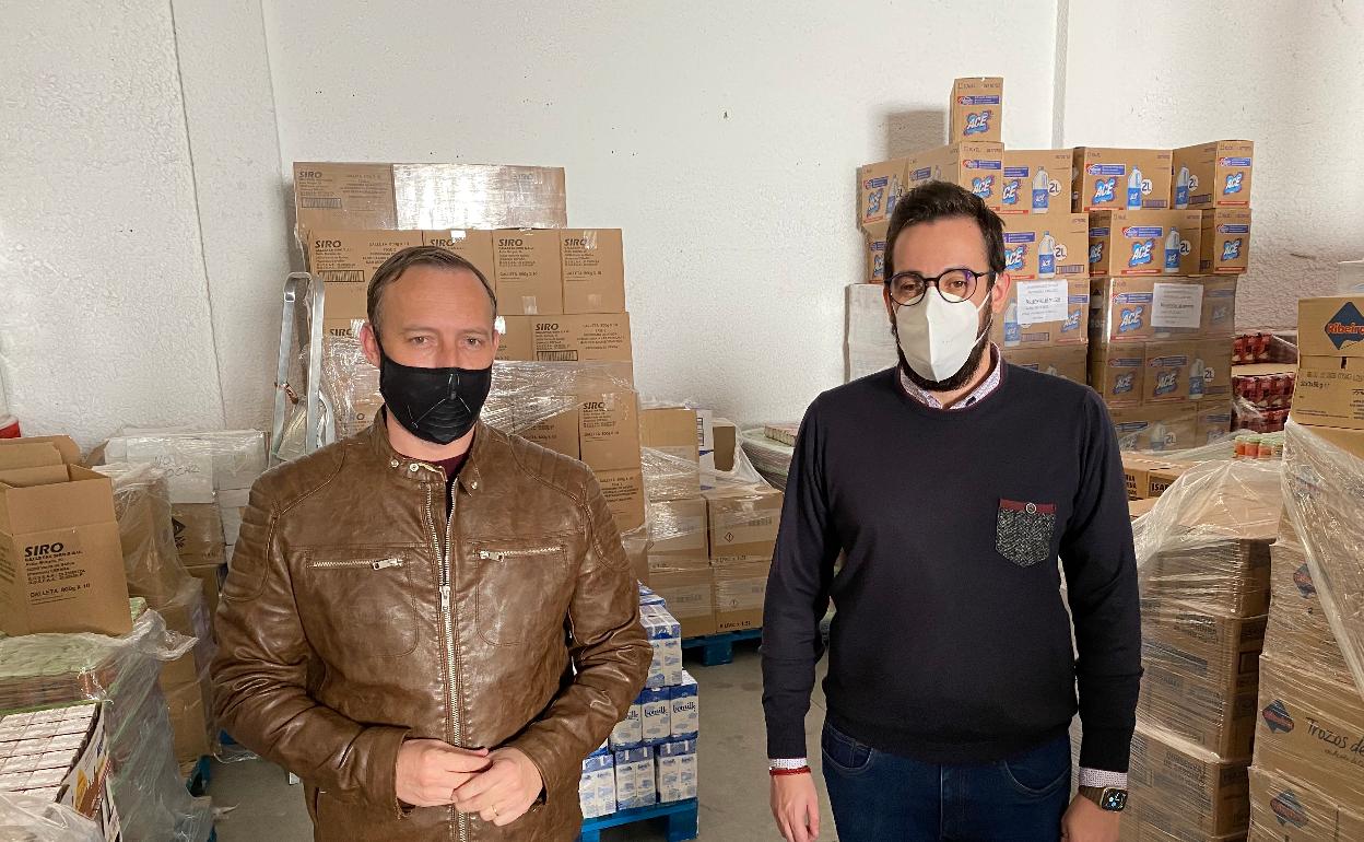 Los ediles David Vilches y Víctor González, en un almacén con alimentos para familias necesitadas. 