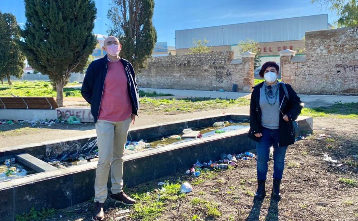 Zorrilla y Macías delante de la tapia del antiguo camposanto, y cerca de una fuente abandonada y llena de suciedad. 