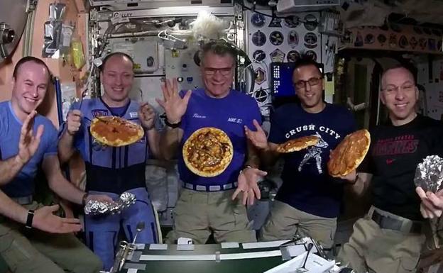 Astronautas con las pizzas que elaboraron en la Estación Espacial Internacional en 2017.