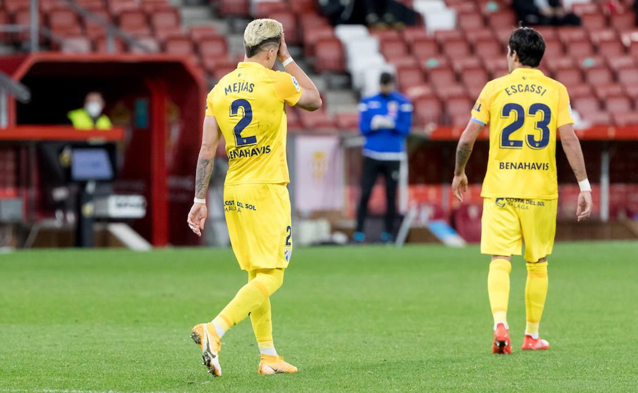 Los jugadores del Málaga Mejías y Escassi se lamentan tras recibir el gol del Sporting.