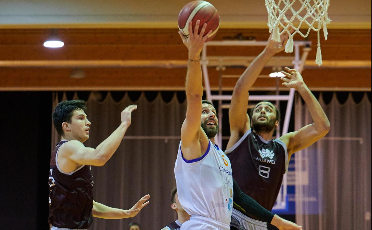 Fuentes penetra a canasta rodeado por dos rivales. 